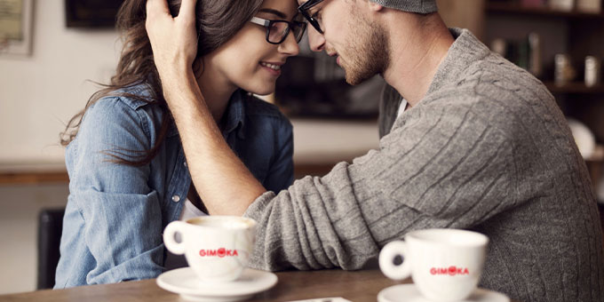 Zwei Personen umarmen sich und trinken Kaffee