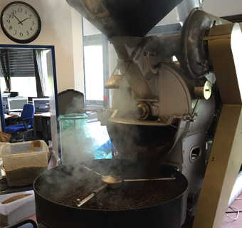 Die dampfenden Kaffeebohnen kommen direkt aus dem Trommelröster ins Luftbett zur Abkühlung